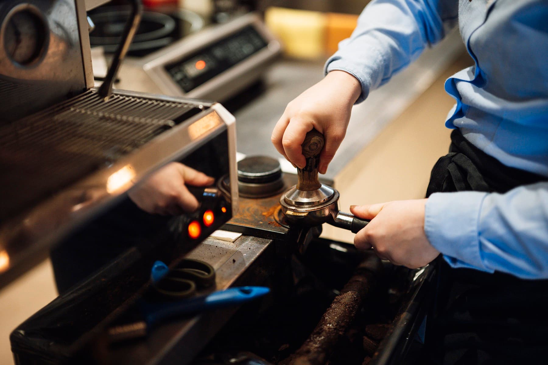 Illustrative photograph of a barista pulling espresso. Not a customer's café.